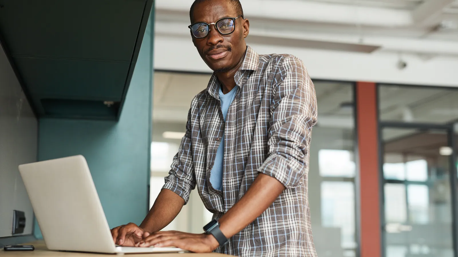A man works at a laptop in a bright New Jersey style office space